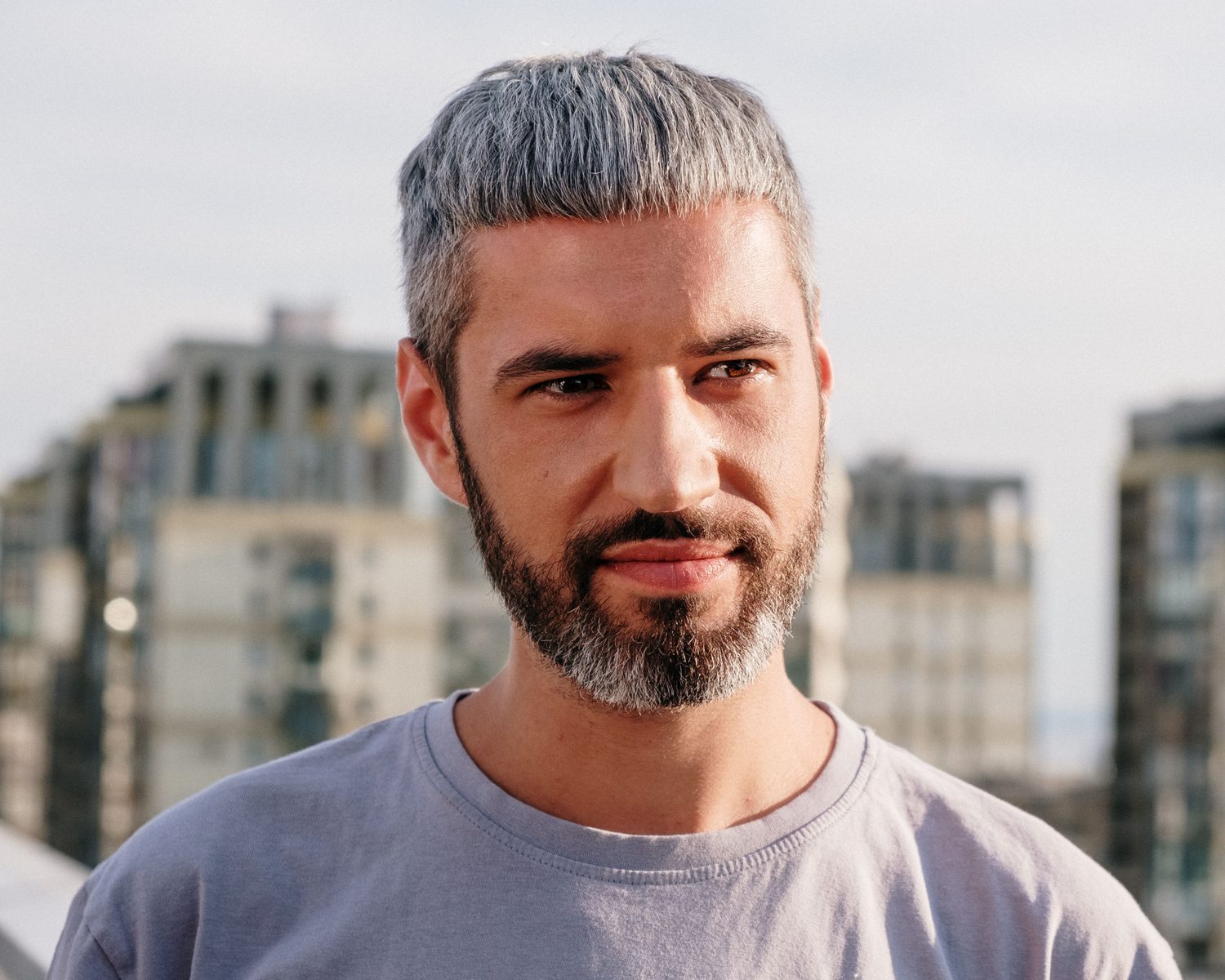 Homme dans la quarantaine aux cheveux poivre et sel bien fournis, en extérieur
